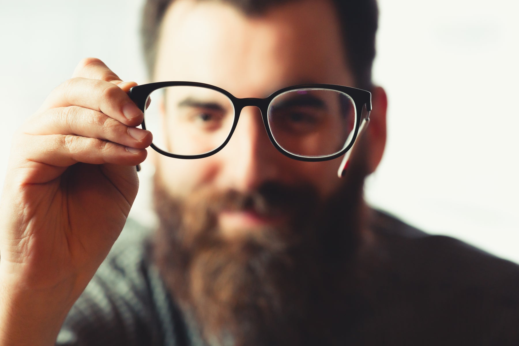 A person holding their glasses in front of them